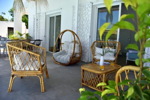 a patio with two chairs and a table and a wicker chair at Mykolodge Majunga in Amborovy