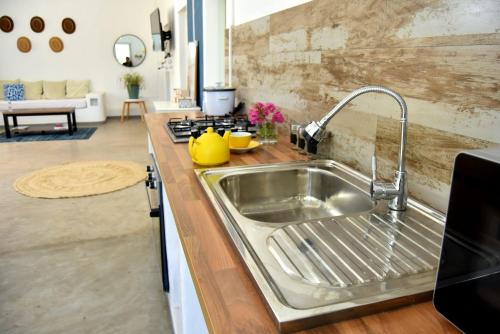 a kitchen with a stainless steel sink and a stove at Mykolodge Majunga in Amborovy