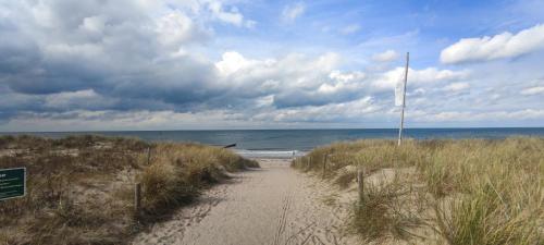 un chemin de terre menant à une plage avec l'océan dans l'établissement Koje 4, à Graal-Müritz