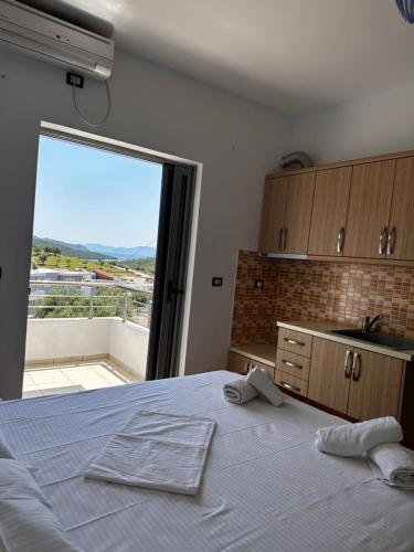 a bedroom with a large bed and a large window at Esmeralda Hotel & Restaurant in Ksamil