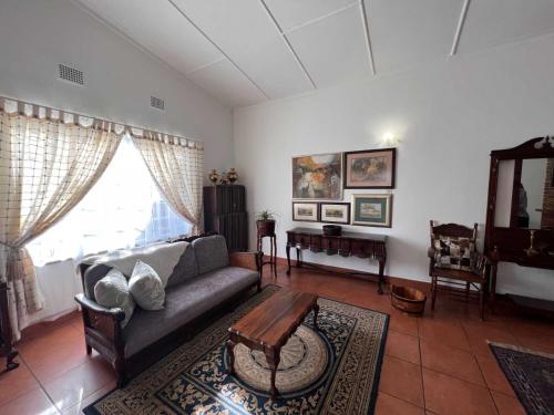 a living room with a couch and a table at Palm House Accomodation in White River
