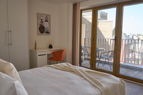 een slaapkamer met een bed en een balkon met een tafel en stoelen bij Luxury Stylish 2 Beds / 2 Baths in Londen