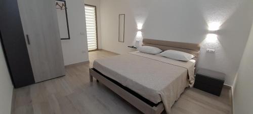 a bedroom with a bed with two pillows on it at Villasimius Appartamento "Il Ginepro" in Villasimius