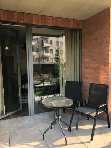 a patio with a table and two chairs on a balcony at Apartamenty 48 Scala in Gdańsk
