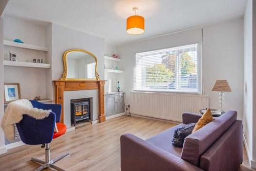 uma sala de estar com um sofá e uma lareira em Relax with the whole family at the cosy cottage - Business rates em Marlborough