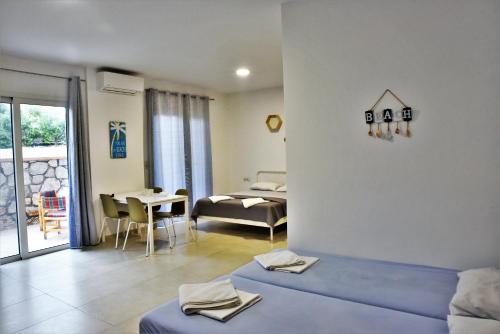 a room with two beds and a living room at Telhinis Hotel & Apartments in Faliraki