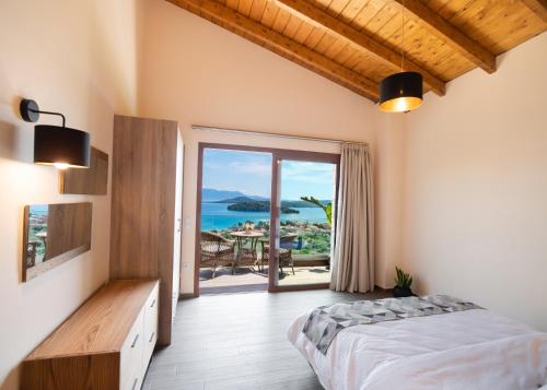 a bedroom with a bed and a view of the ocean at 180 Villas in Nydri