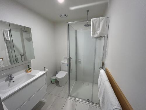 ein Bad mit einer Dusche, einem WC und einem Waschbecken in der Unterkunft Bicheno Wildflower Sands coastal retreat in Bicheno