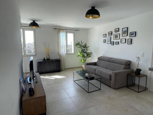 a living room with a couch and a tv at Le Lourmarinois in Lourmarin