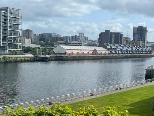 a large body of water with a city in the background at River view Apartment in Glasgow