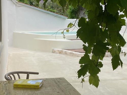 a book sitting on a table next to a chair at Lotusland, a relaxing house at Amari Rethymno in Agia Fotini