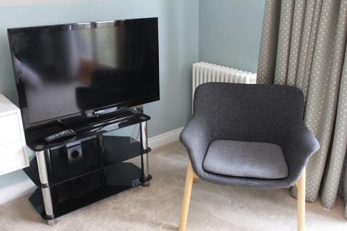 a chair sitting in front of a flat screen tv at Boutique double room with country village views in Wilby