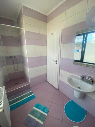 y baño de color rosa con lavabo y ducha. en Apartament Oana, en Băile Felix