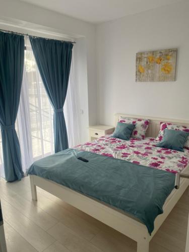 1 dormitorio con 1 cama con cortinas azules y ventana en Apartament Oana, en Băile Felix