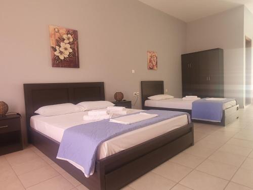 a bedroom with two beds and two tables at Galini Apartments Sikinos Travel in Sikinos