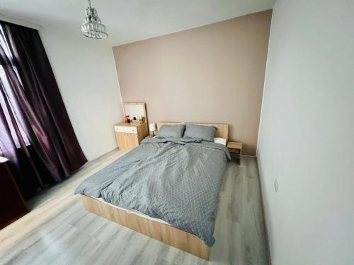 a bedroom with a large bed in a room at Midtown Apartment in Kŭrdzhali