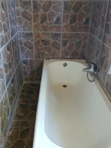 bañera blanca con grifo en el baño en Beautiful 1-Bed Cottage in Juliasdale en Juliasdale