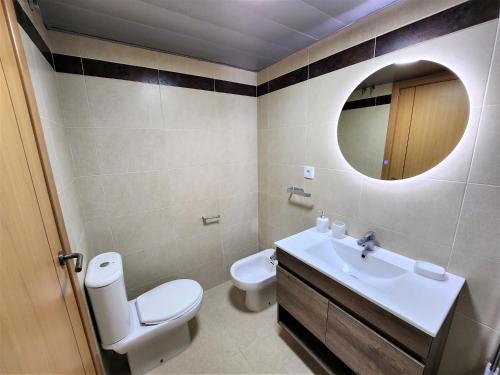 ein Badezimmer mit einem WC, einem Waschbecken und einem Spiegel in der Unterkunft Apartamento La Gambita de Garrucha in Garrucha