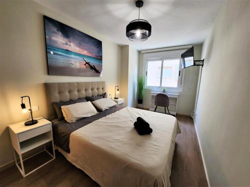 ein Schlafzimmer mit einem Bett mit einer schwarzen Tasche darauf in der Unterkunft Apartamento La Gambita de Garrucha in Garrucha