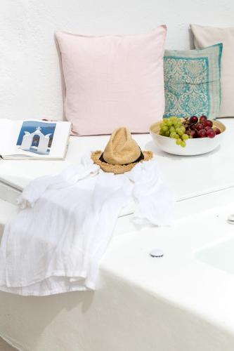 a hat sitting on a table with a bowl of fruit at Cleo's Dream Villa in Oia