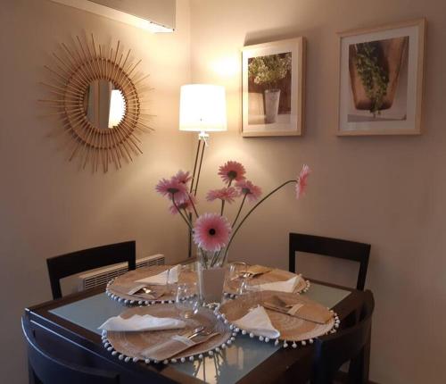 einen Esstisch mit einer Blumenvase darauf in der Unterkunft appartement la Croix Valmer in La Croix-Valmer