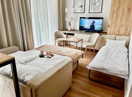een hotelkamer met 2 bedden en een televisie bij EnergyApart Mielno in Mielno