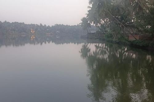 a large body of water with trees in the background at Ocean Pearl in Kozhikode