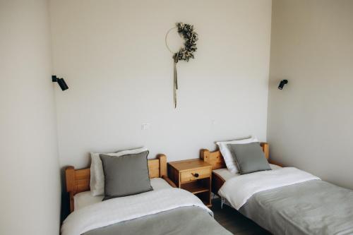 um quarto com duas camas e um relógio na parede em Durbes Atvari - brīvdienu mājas ar saunu em Durbe
