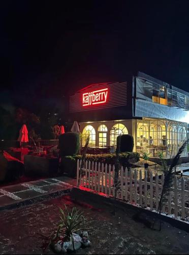a fast food restaurant with a lit up sign at night at Kaffberry Cafe & Homestays in Kūd