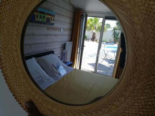 een slaapkamer met een bed in een ronde spiegel bij Studio indépendant chez l'habitant avec piscine et cuisine extérieure in La Rochelle