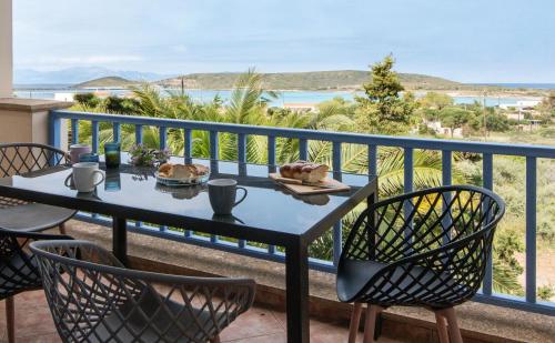 a table and chairs on a balcony with a view of the ocean at Filoxenes Katoikies in Dhiakofti