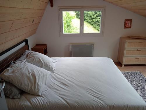 1 dormitorio con 1 cama blanca grande y ventana en Châlet montagne 6 personnes, en Laruns