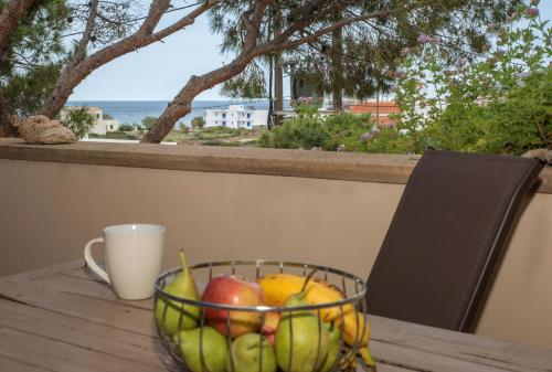 a bowl of fruit sitting on a table with a cup at Filoxenes Katoikies in Dhiakofti