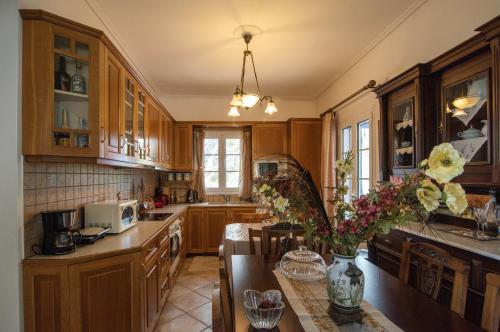 a kitchen with wooden cabinets and a table with flowers at Filoxenes Katoikies in Dhiakofti