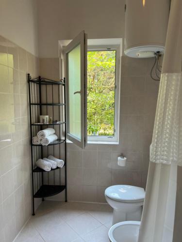 een badkamer met een toilet en een raam bij Villa Claudia Beach Apartment in Premantura