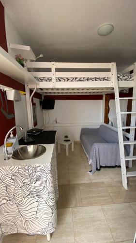 una camera con letto a castello e lavandino in una stanza di Mini House Nane a Playa Honda