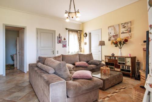 a living room with a brown couch and a table at Filoxenes Katoikies in Dhiakofti