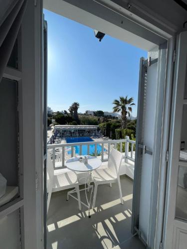 a balcony with a table and chairs and a pool at Zoumis Residence in Naousa