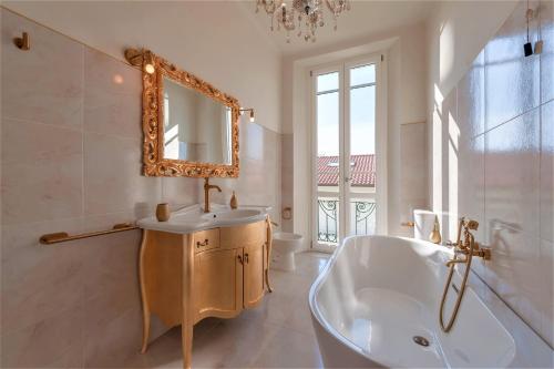 a bathroom with a tub and a sink and a mirror at [- Poetic Seafront Penthouse Versilia -] in Massa