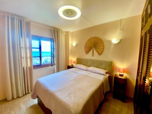 a bedroom with a large bed and a window at Beautiful apartment near LaMata Beach with PANORAMA SEA view!!! in Torrevieja