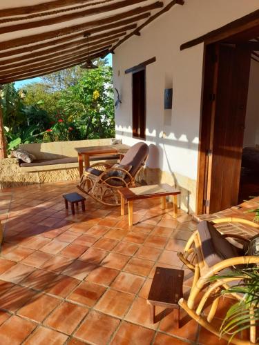 a patio with chairs and tables on a tiled floor at Casa Alamanda B&B in Barichara