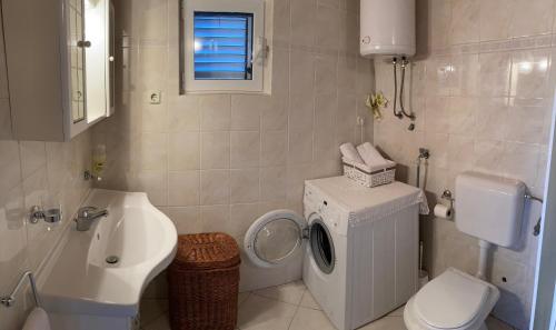 a bathroom with a toilet sink and a washing machine at Apartment Jukica 2 - 4 persons in Vis