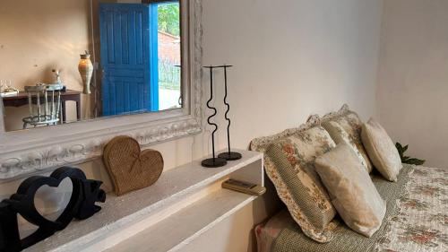 a bedroom with a mirror and a bed with pillows at Amorada in Santo Amaro