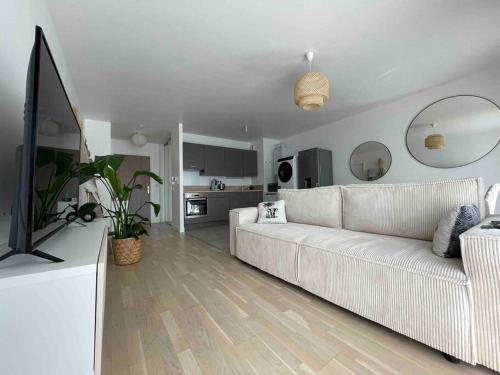 un salon avec un canapé blanc et une télévision dans l'établissement Le Cœur Urbain, au Mans