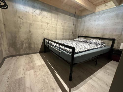 Bett in einem Zimmer mit einer Betonwand in der Unterkunft Łap chwilę Ostrowo in Ostrowo