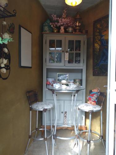 a kitchen with two bar stools and a cabinet at Pousada Café Country in Petrópolis