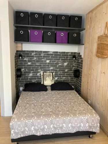 une chambre avec un lit et un mur de briques dans l'établissement Tournamy Les Olivier, à Mougins