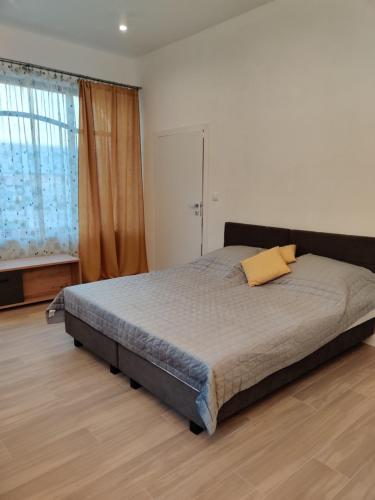 a bedroom with a bed with a yellow pillow on it at apartament 2 pokoje in Kamień Pomorski