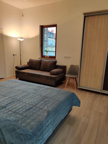 uma sala de estar com uma cama e um sofá em apartament 2 pokoje em Kamień Pomorski