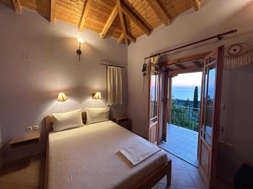 a bedroom with a bed and a door to a balcony at Porto Katsiki Guest Houses in Athanion
